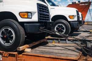 Heavy-duty garbage trucks prepared for ocean shipment.